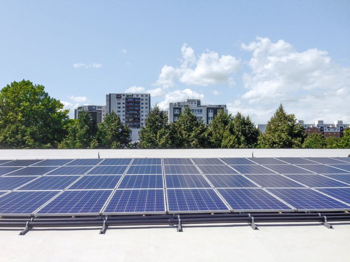 Eine Photovoltaikanlage und im Hintergrund sind Hotelgebäude zu sehen