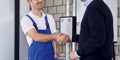 Ein Monteur und ein Kunde die sich die Hand geben