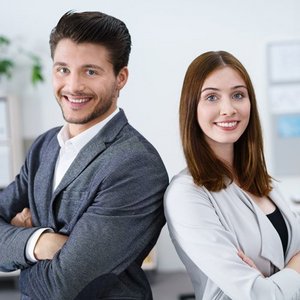 Ein Mann und eine Frau die Schulter an Schulter stehen in einem Buero