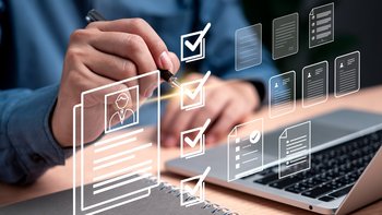 Ein Laptop und ein Bewerbungs header mit einer Männerhand die ein Kugelschreiber hält